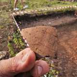 L�archeologo ci mostra frammenti di terracotta su cui sono ancora visibili le tracce delle unghie del fabbricatore... 